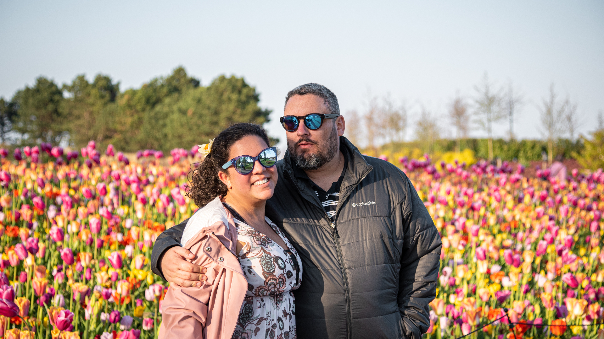Juliano e Mariana, fundadores da Desdobra Viagens, em um campo de tulipas